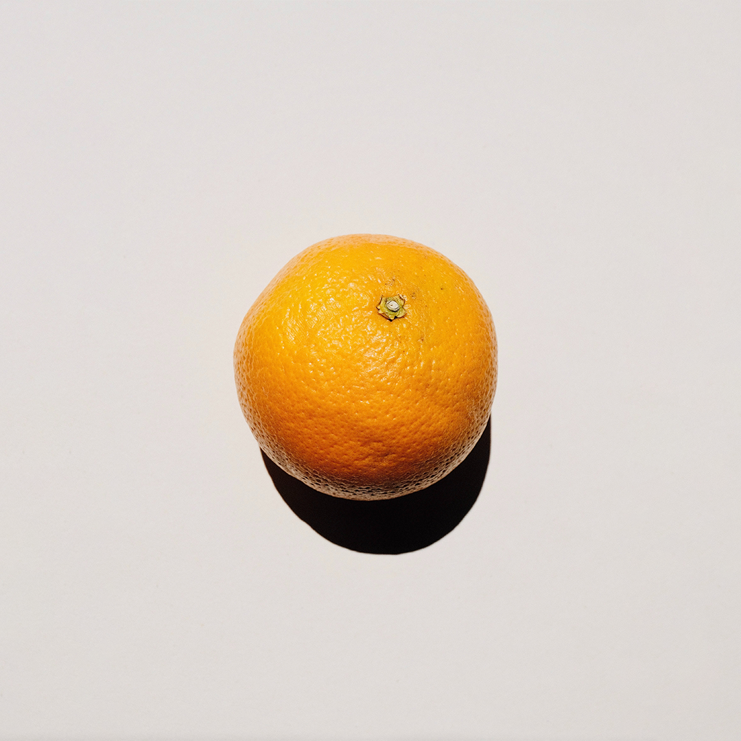 An orange with the shadow on the bottom